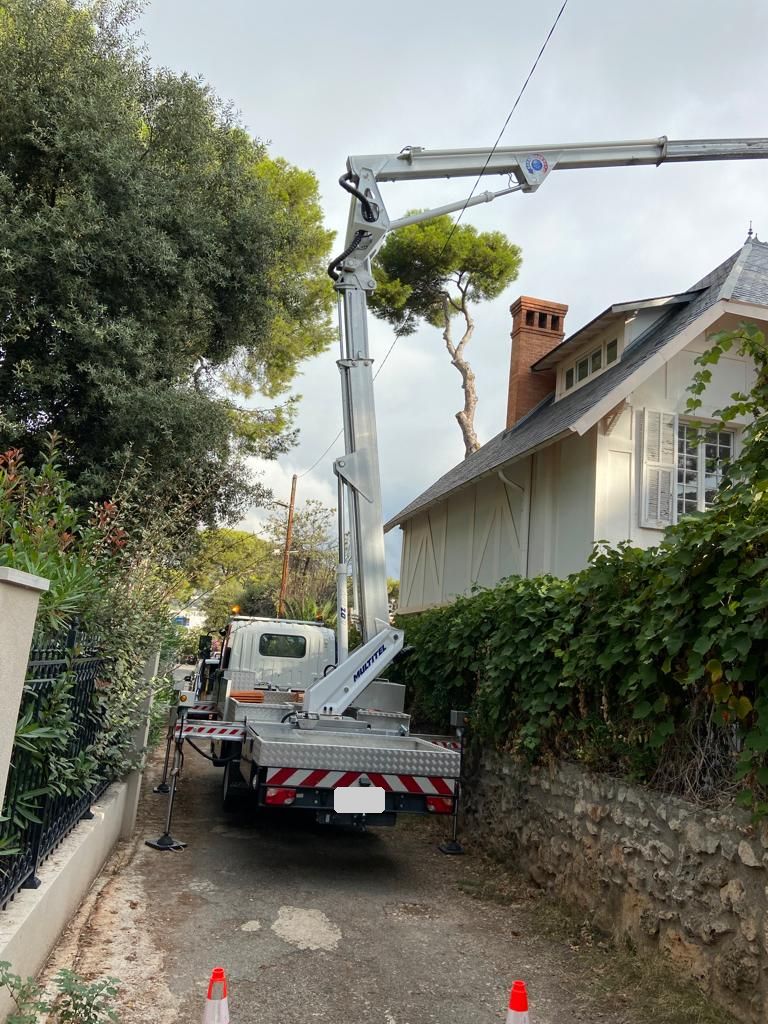 Camion-nacelle installé dans une allée devant une villa